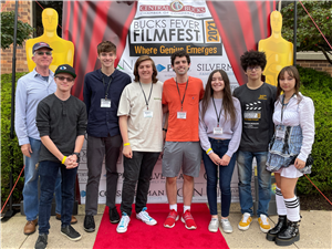 Mr Davey, Ethan, Luke, Billy Shamus, Skylar, Abner, Dary stand in front of the Bucks Film Festival backdrop